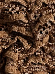 Macrodetail van de ingewikkelde bruine kralentextuur van deze sexy bikini-stof close-up