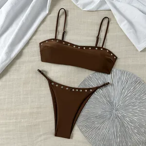 Detail van bruine bikini met studs, bandeau top en zilveren metalen klinknagels
