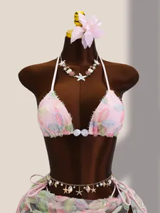 Détail d'un bikini rose brodé de fleurs avec paillettes et jupe en résille sur mannequin