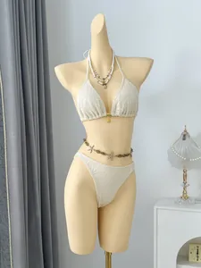 Detailed view of the elegant beige leaf-patterned crochet bikini on a display mannequin
