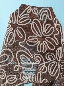 Close-up of brown mesh beach cover-up with white floral embroidery texture