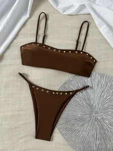 Gedetailleerd overzicht van een bruine tweeledige bikini met zilveren klinknagels