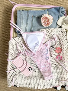 Primer plano de un bikini rosa con lentejuelas y funda de móvil a cuadros a juego