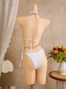 Achteraanzicht van elegante witte driedelige bikini met decoratieve schelpen-tailleketting.