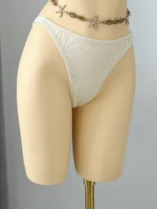 Detailed view of white crochet bikini bottom featuring an intricate leaf pattern lace