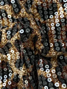 Dettaglio macro di tessuto leopardato con paillettes trasparenti per costumi da bagno.
