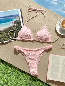 Vista detallada del conjunto bikini rosa bordado con textura de encaje floral fino