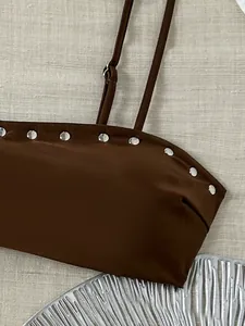Macro-opname van een bruine bikinitop met zilveren studs en hoogwaardige materialen