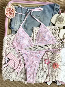 Vista detallada de un conjunto de bikini rosa con lentejuelas y apliques de flores