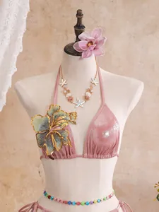 Detailed view of pink glitter bikini top with sequin flower and starfish jewelry