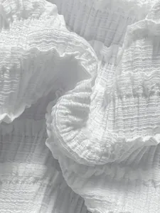 Détail macro du tissu à volants blanc texturé pour les maillots de bain bikini