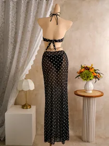 Achteraanzicht van een driedelige bikini met stippen en een lange mesh rok-cover-up