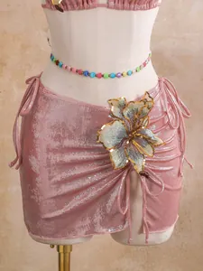 Detailed macro view of pink metallic bikini skirt with a large sequined flower accent.