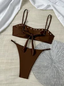 Gedetailleerd overzicht van bruine bikini met studs, bandjes en strikdetail achter