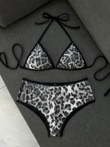 Vista dettagliata di un bikini con paillettes leopardate e accenti scintillanti argento-nero.