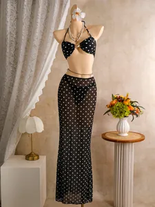 Driedelige stippenbikini-set met een lange netrok en detail van een schelpgesp.