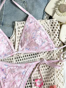 Vista detallada del bikini de lentejuelas rosas con apliques florales 3D y malla