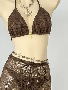 Close-up detail of a brown leaf pattern three-piece bikini set with matching mesh cover-up