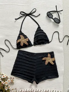 Vue détaillée d'un bikini texturé noir avec écussons d'étoiles de mer dorées