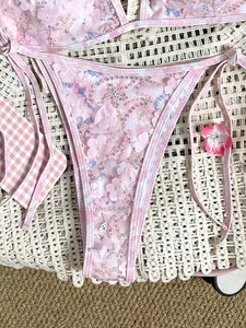 Vista detallada de un bikini rosa con lentejuelas y apliques florales 3D en malla