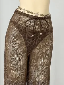 Detail view of brown leaf patterned mesh lace cover-up pants with metallic drawstring ends