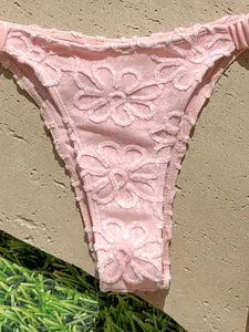 Primer plano de braguita de bikini rosa con intrincado bordado floral texturizado en 3D
