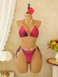 Levendige Boheemse fuchsia tie-dye bikiniset op een paspop met zomerse strandaccessoires