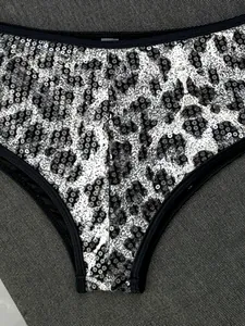 Primo piano di paillettes leopardate su uno slip bikini con rifiniture nere