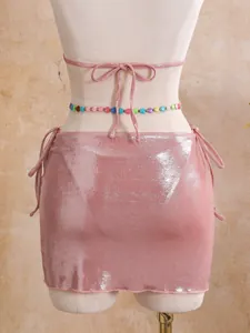 Close-up rear view of sexy pink shimmering metallic bikini set and matching mini skirt