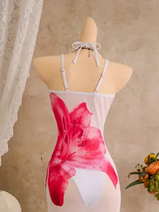 Prachtig detail van een witte mesh strandjurk met een grote roze lelieprint-top