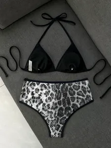 Dettaglio di un set bikini con paillettes leopardate e top a triangolo nero con lacci al collo