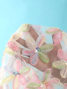 Gros plan sur un tissu en maille transparente avec des appliques de fleurs 3D et des sequins