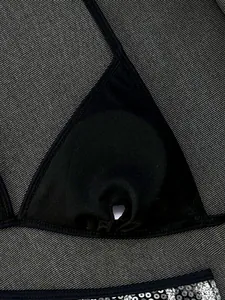 Dettaglio di un top bikini nero a triangolo con fessura per imbottitura e paillettes