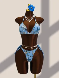 Détail d'un bikini bleu avec broderie florale et paillettes sur un mannequin d'exposition