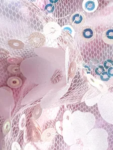 Detalle macro de tela de malla rosa elegante con lentejuelas y flores en 3D