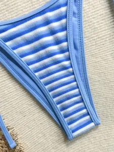 Detalle macro de la tela de bikini de rizo a rayas azules y blancas con costuras finas