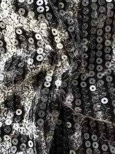 Vista macro di tessuto leopardato con paillettes argento scintillanti