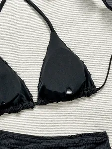 Détail en gros plan d'un haut de bikini triangle noir texturé avec fente de rembourrage