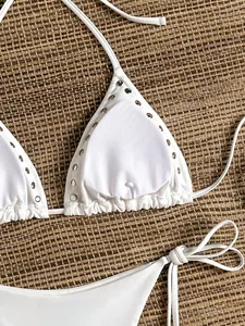 Detailed view of white triangle bikini top featuring silver metal rivet stud embellishments