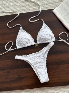Detalle del bordado de encaje floral 3D blanco en un conjunto de bikini de dos piezas