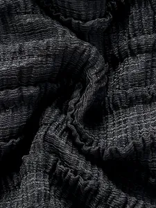 Vue macro détaillée du tissu texturé smocké noir sur un maillot de bain bikini de plage