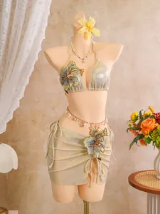 Detail showing 3-piece shiny bikini set with elegant floral embroidery and shell accessories.