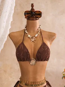 Gedetailleerd aanzicht van bruine gehaakte bikini-top op een etalagepop voor vakantie