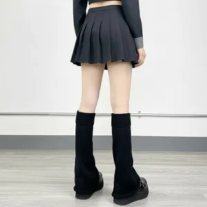 Vue arrière de jambières en tricot noir avec jupe plissée et chaussures à semelles compensées