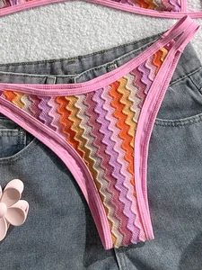 Primer plano de bikini de ganchillo bohemio con estampado en zigzag y borde rosa detalle.