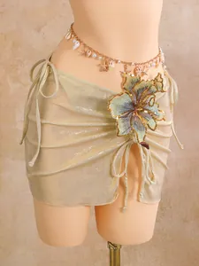 Detailed view of shiny gold beach wrap skirt featuring elaborate flower embroidery