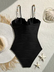 Bañador de una pieza negro con textura de ondas retro y tirantes decorados con cuentas