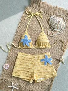 Détail en vue de dessus d'un bikini jaune avec des étoiles de mer bleu pailleté