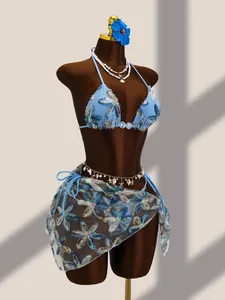 Détail d'un ensemble bikini bleu avec broderies florales et paréo en mesh à paillettes