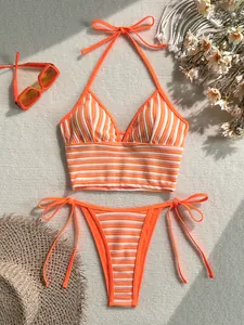 Detalle de bikini de rizo con rayas naranjas sobre fondo de textura con gafas